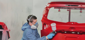 Painter spraying red base.